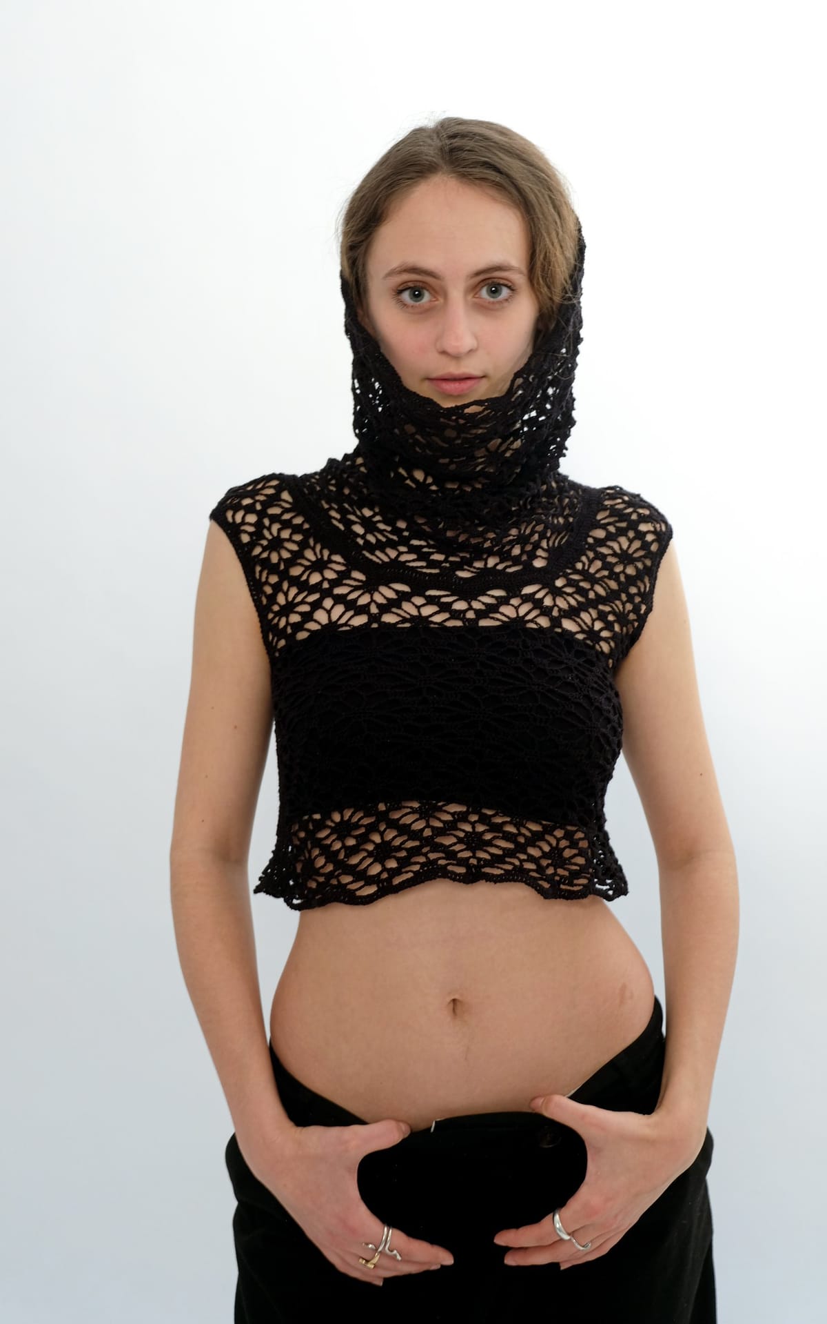 Model im feinen schwarzen Häkelspitzentop mit gehäkelter Kapuze