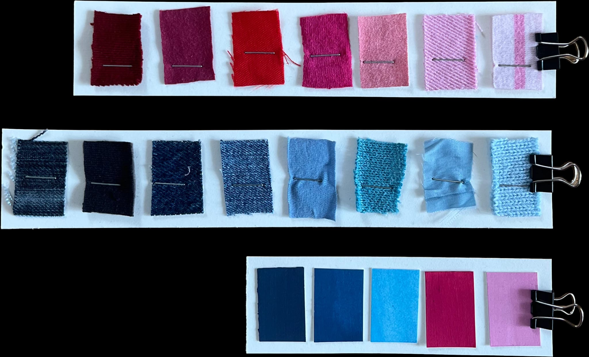 Stoffproben, nach Farben sortiert in Rot, Rosa und Blau